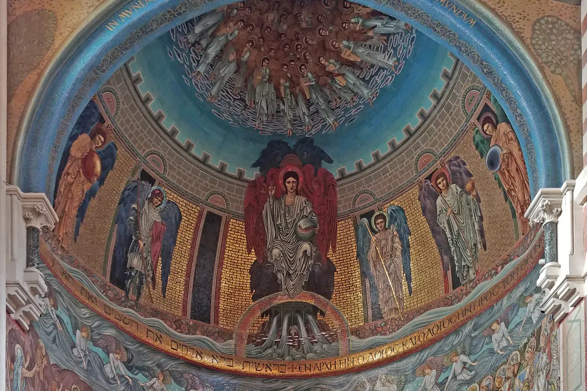 A semicircular apse whose gold-ground mosaic shows a seated figure between angels beneath a blue arch, with a long procession of saints and soldiers along the lower wall.